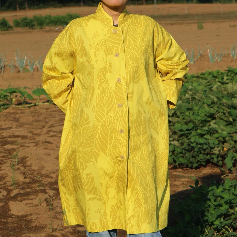 AMONGのアトリエコート「カンナ」光。２色のイエローのカンナ柄。Aラインのロング丈のフリーサイズで着回し自在。日本製の1点モノアウターです。