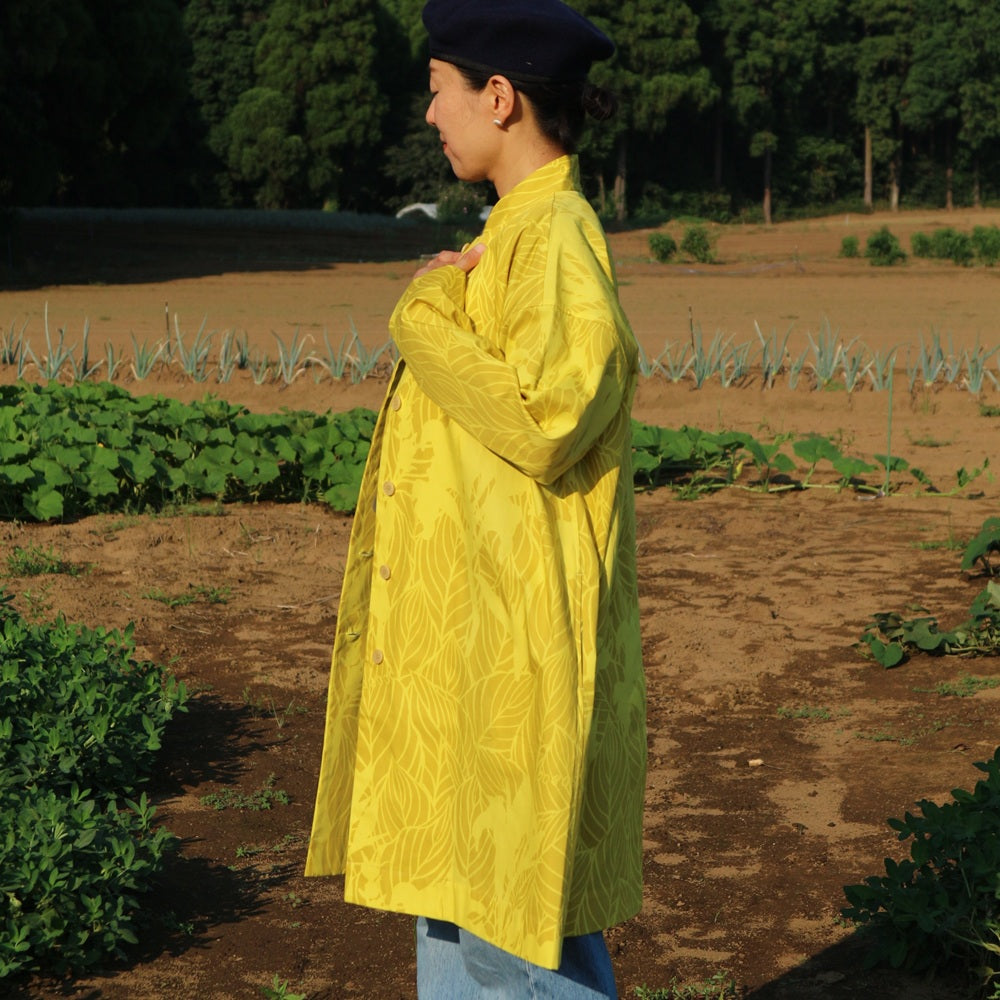 AMONGのアトリエコート「カンナ」光。２色のイエローのカンナ柄。Aラインのロング丈のフリーサイズで着回し自在。日本製の1点モノアウターです。