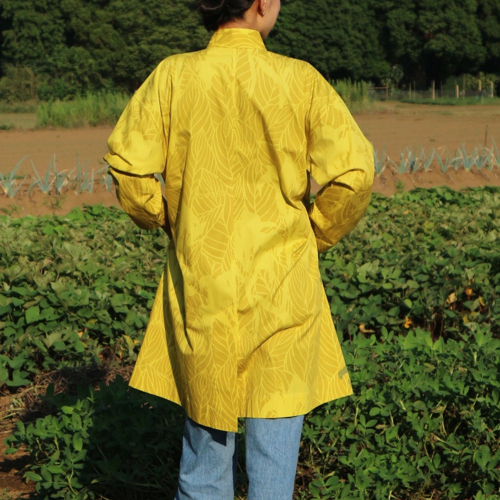 AMONGのアトリエコート「カンナ」光。２色のイエローのカンナ柄。Aラインのロング丈のフリーサイズで着回し自在。日本製の1点モノアウターです。