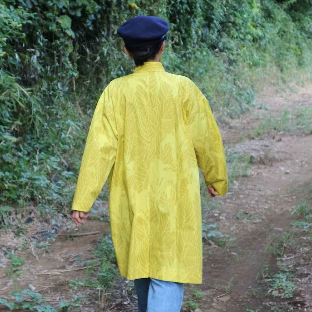 AMONGのアトリエコート「カンナ」光。２色のイエローのカンナ柄。Aラインのロング丈のフリーサイズで着回し自在。日本製の1点モノアウターです。