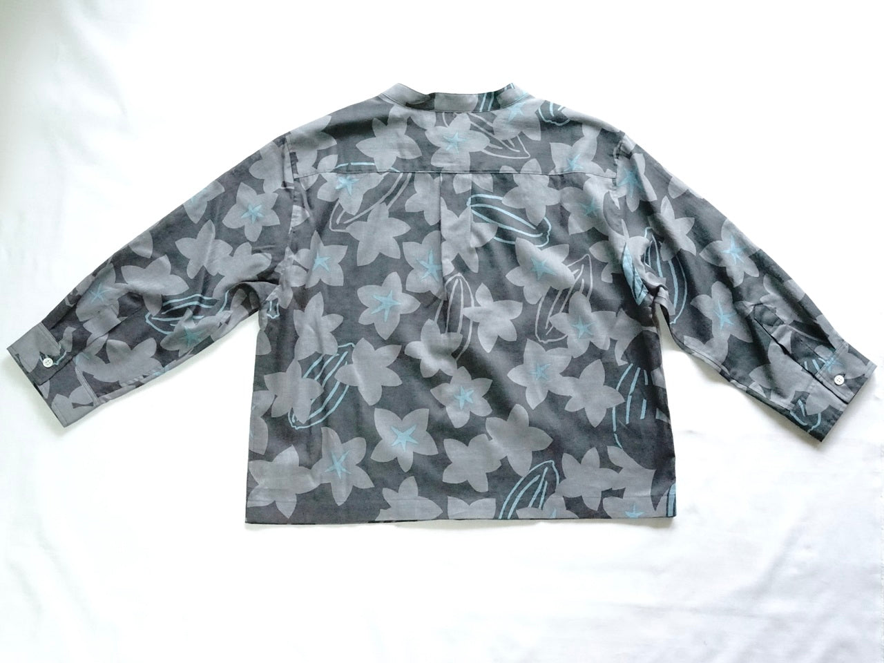 AMONGの花柄シャツ スターフルーツ シルエット 木柄。チャコールにターコイズが映えるスターフルーツの星が印象的。コットン100%が日常に心地よい一枚。