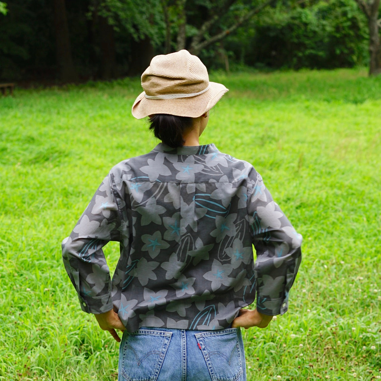 AMONGの花柄シャツ スターフルーツ シルエット 木柄。チャコールにターコイズが映えるスターフルーツの星が印象的。コットン100%が日常に心地よい一枚。